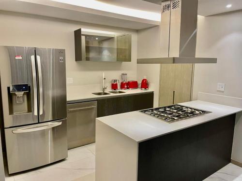 a kitchen with a stainless steel refrigerator and a stove at Departamento B, Santa Fe, Piso 42 in Mexico City