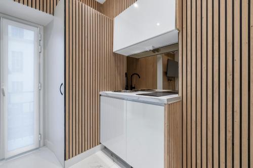 une cuisine avec un comptoir blanc et un évier dans l'établissement Nice Renting - 5FRANCE - Luxe Suite & Comfort Seafront Massena, à Nice