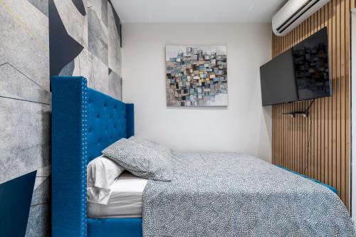 - une chambre avec un lit à tête bleue dans l'établissement Nice Renting - 5FRANCE - Luxe Suite & Comfort Seafront Massena, à Nice