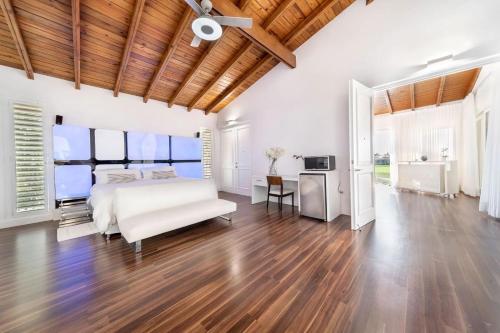 una camera con letto bianco e soffitto in legno di Casa de Campo Elegance - 8-Bedroom Golf View Villa a La Romana