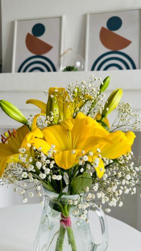 a vase filled with yellow flowers on a table at Hotel Tamar Mepe in Kutaisi