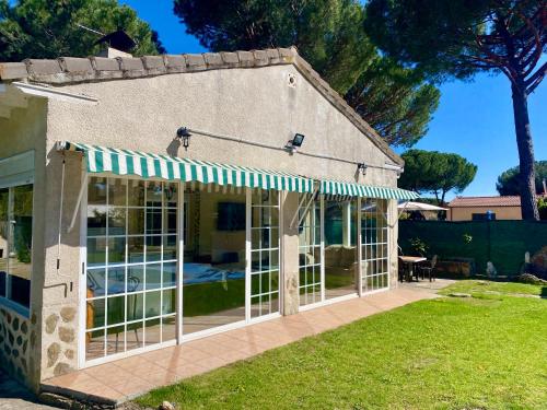 une maison avec une terrasse couverte avec un auvent dans l'établissement Chalet con piscina El Refugio de Venecia, à El Campillo