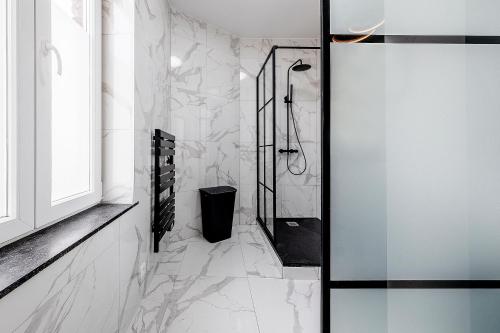 uma casa de banho com paredes em mármore branco e um chuveiro em Marshmallow em Liège