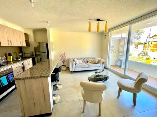 uma cozinha e uma sala de estar com um sofá em Jardines del Pacífico 3 em La Serena