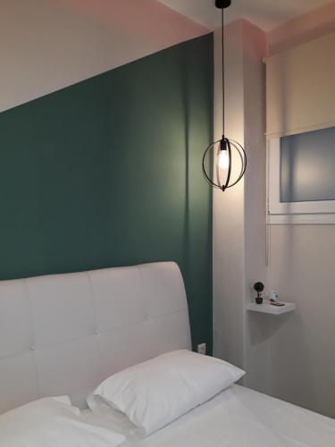 a bedroom with a green wall and a white bed at DramaMine2 in Drama