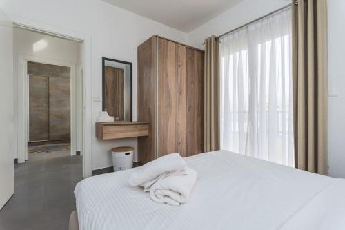 a bedroom with a white bed with towels on it at Luna 2-BR in Mar Mikhael in Beirut
