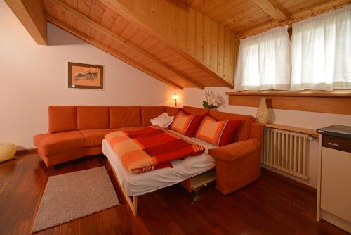 sala de estar con cama y sofá en Apartments Rezia, en Ortisei