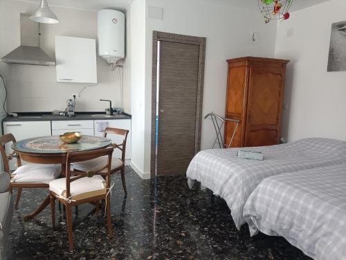 Cúllar-Vega的住宿－Alojamiento Vega Granada，厨房配有桌子、两把椅子和一张床