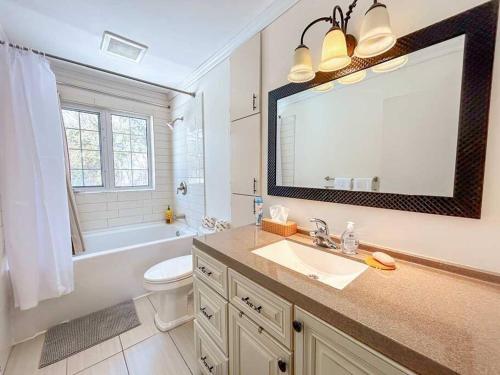 a bathroom with a sink and a toilet and a mirror at Spacious 5BR home. Close to everything! in Gatineau