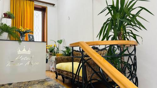 a stairway with a chair and a plant at Hotel Tamar Mepe in Kutaisi