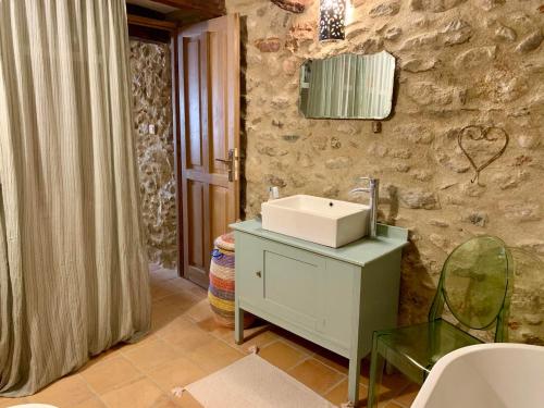 une salle de bain avec un lavabo et un mur en pierre dans l'établissement Maison Historique rue Vermeille Argeles sur mer, à Argelès-sur-Mer