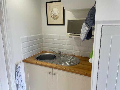 a small kitchen with a sink and a microwave at The Herb Garden in Great Carlton