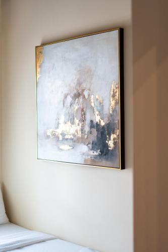 a painting hanging on a wall above a bed at Bodrum Suites in Ioannina
