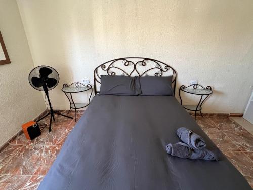 a bedroom with a bed with two tables and a fan at Piso Completo cerca de Artes Y Ciencias in Valencia