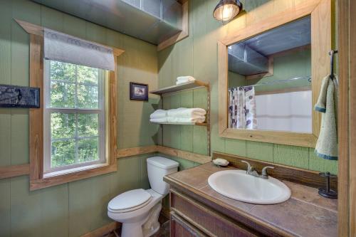 y baño con aseo, lavabo y espejo. en River Bend Lodge Heflin Home in the Woods!, en Heflin