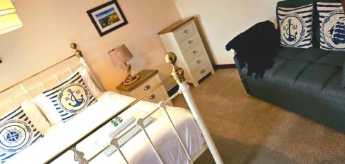 a bedroom with a bed and a dresser next to a bedsenalsenalsenal at The Cornishman Inn in Tintagel