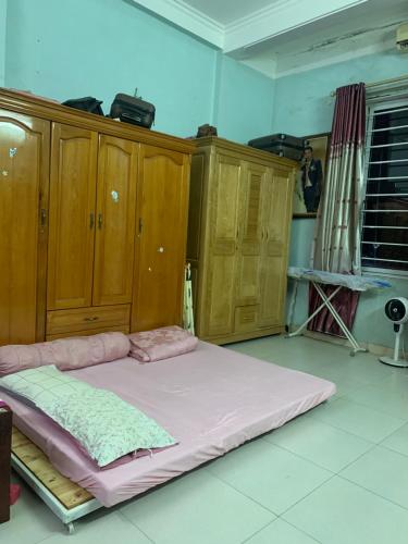 Cama grande en habitación con armarios de madera en nhà hưng hà, en Dien Bien Phu