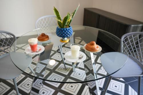 a glass table with some pastries and drinks on it at La Marina - Casa Assuntina in Letojanni