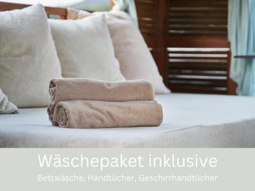 a stack of towels sitting on top of a bed at Apartment Meeresbrise mit Balkon in Husum