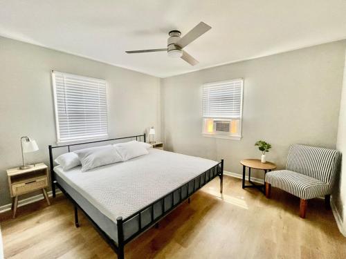 a bedroom with a bed with a ceiling fan and a chair at Cathedra 3l-Charming Apartment walk to UNMC in Omaha