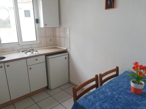 una cocina con una mesa con un jarrón de flores. en Apartment Jelas, en Živogošće