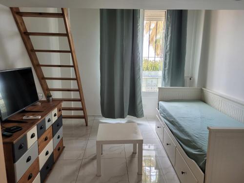 une chambre avec un lit, un bureau et une télévision dans l'établissement 2 pièces promenade des anglais, à Nice