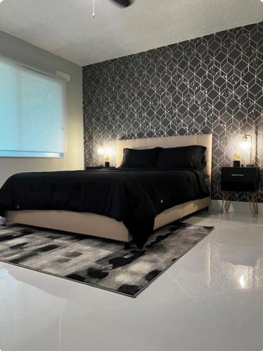 a bedroom with a black and white bed and a wall at Luxe Waterfront home near beach in Fort Myers