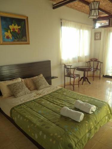 a bedroom with a large bed with two towels on it at Punta Pacífico Bungalows Máncora in Máncora