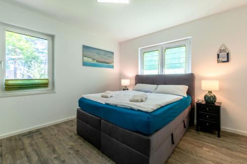 a bedroom with a bed and two windows at Villa-Grenzenlos in Glowe