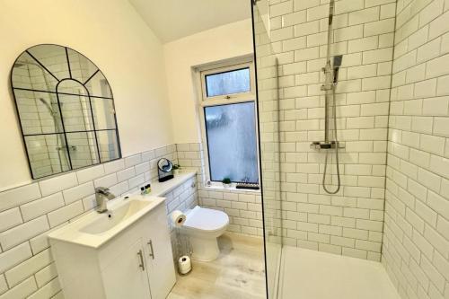 a bathroom with a toilet and a sink and a shower at Sophia's Retreat - 2 Floor 4 Bed Apartment - Newport - Coastal Getaway in Newport