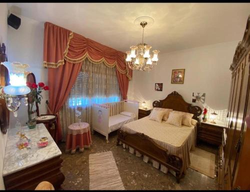 a bedroom with a bed and a chandelier at Casa VENTA RUIZO in Lorca