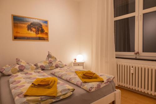 um quarto com 2 camas com toalhas amarelas em Altes Pfarrhaus em Oberhausen