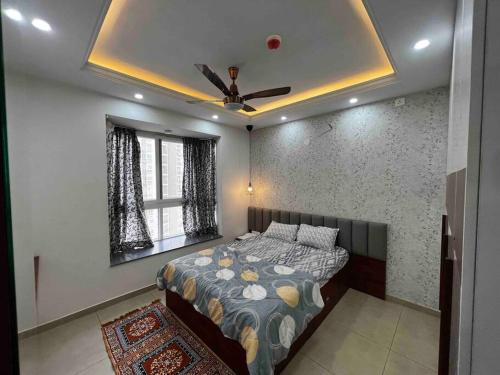 a bedroom with a bed and a ceiling fan at Cozy 1 BHK apartment in Bhartiya City in Yelahanka