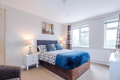 a bedroom with a bed and two windows at Holcombe Guest House in Barnetby le Wold