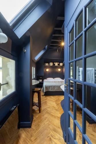 Cette chambre bleue comprend un lit et une fenêtre. dans l'établissement Midnight Suite - Marais, à Paris