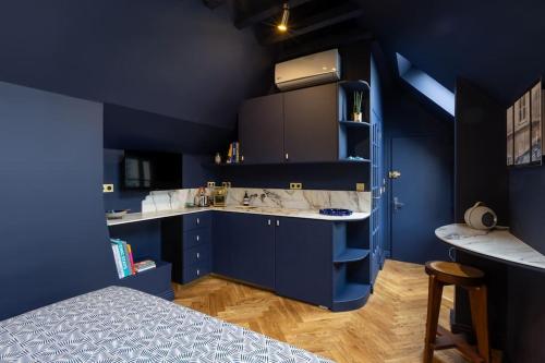- une cuisine avec des placards bleus et un lit dans une chambre dans l'établissement Midnight Suite - Marais, à Paris
