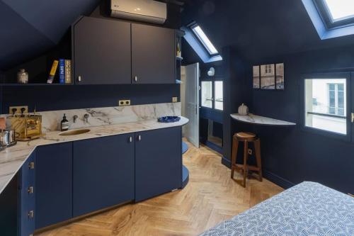 - une cuisine bleue avec un évier et un comptoir dans l'établissement Midnight Suite - Marais, à Paris