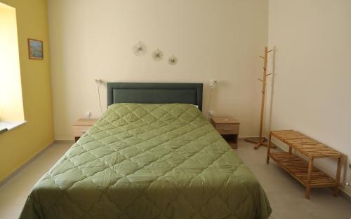 1 dormitorio con 1 cama con edredón verde en Kallichoron 2, en Kavala