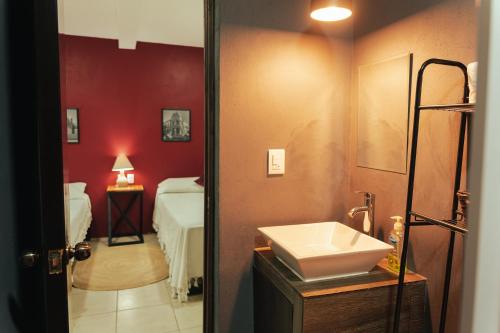 uma casa de banho com um lavatório e um quarto com uma cama em Casa Don José: GRANADAS em Oaxaca City