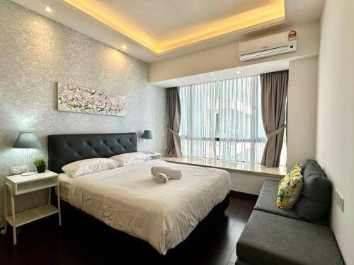 een slaapkamer met een bed, een raam en een bank bij R&F Summer Suite 2B2B in Johor Bahru