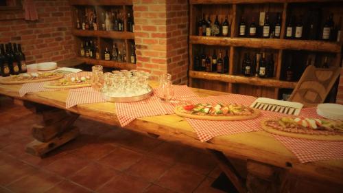 a wooden table with pizzas and wine glasses on it at Pansion Rody in Gornja Stubica