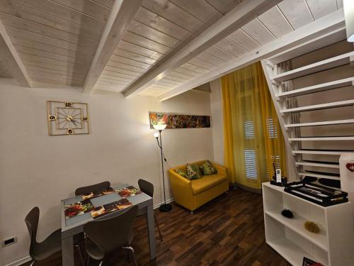een woonkamer met een tafel en een gele bank bij La Casetta di Vale in Taranto