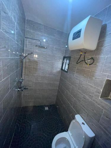 y baño con ducha, aseo y ducha. en Studio Room Apartment, en Port Harcourt