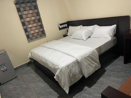sypialnia z dużym łóżkiem z białą pościelą i poduszkami w obiekcie Studio Room Apartment w mieście Port Harcourt