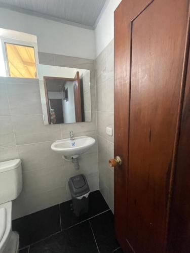 ビリャビセンシオにあるHotel Descanso Inn Villavicencioのバスルーム(洗面台、トイレ、鏡付)