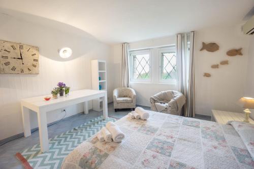 a bedroom with a bed and a desk and a clock at BGItalianVacation - Ville Li Conchi in Castiadas