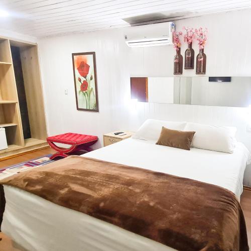 um quarto com uma cama e uma cadeira vermelha em Pousada Mima em Gramado