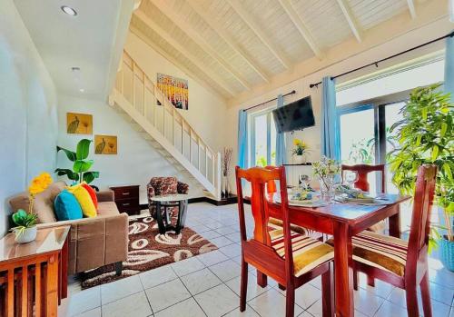 een woonkamer met een tafel en een bank bij Palm JA SCA31 - Relaxing 1 BR with Beach & Pool Access in Montego Bay