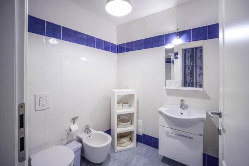a white bathroom with a sink and a toilet at BGItalianVacation - Ville Li Conchi in Castiadas
