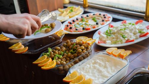 a table topped with plates of food and fruits at Jiger Palace Hotel in Erbil